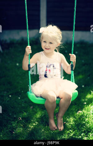 Blonde Kind tutu Schwingen schwingen garten sommer, Kindheit Konzept, Freiheit, unbeschwerte, glückliche Zeiten, Zeit ihres Lebens, Freude Konzept, glücklich Stockfoto