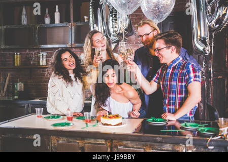 Junges Mädchen feiert ihren Geburtstag mit ihren Freunden den Kerzen ausblasen Stockfoto