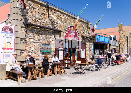 Menschen Essen und genießen Sie einen Drink in der Sonne vor einem Fischrestaurant in Howth, Dublin, Irland. Stockfoto