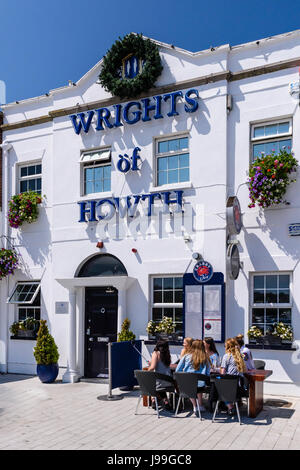 Menschen Essen und genießen Sie einen Drink in der Sonne vor einem Fischrestaurant in Howth, Dublin, Irland. Stockfoto