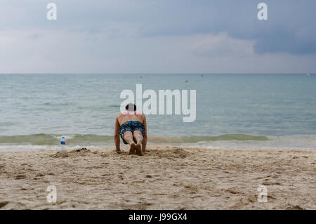 Training-Übung. ein schöner aktive Mann mit muskulösen Körper Push Ups Übungen Fit. Sportlich sportlich männlichen Training am Strand, Outdoor-Training. S Stockfoto