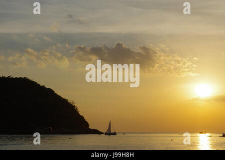 ein Segelboot Sonnenuntergang Fantasy Schiff mit vollen Segeln Segeln Silhouette gegen einen bunten orange sunset Himmel öffnen Stockfoto