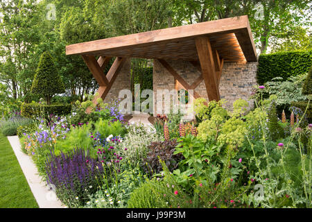 Eine Eiche und Stein Loggia, umgeben von bunten Dichte Bepflanzung im The Morgan Stanley Garten entworfen von Chris Beardshaw bei der RHS Chelsea Flower Show Stockfoto