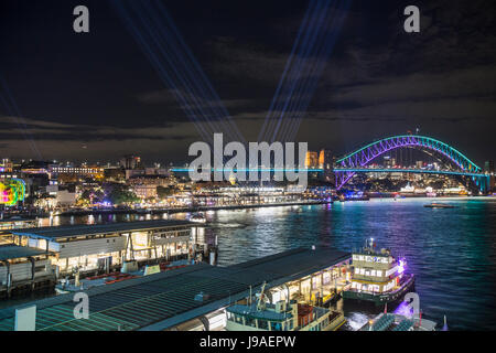 Vivid Sydney Lichtshow 2017, Vivid Sydney projiziert Licht auf die Hafenbrücke von Sydney und über den Circular Quay, mit Lichtstrahlen, die in den Himmel zeigen, Sydney, Australien Stockfoto