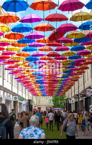 Bath, Somerset, Großbritannien Wetter. 1. Juni 2017. Die Menschen gehen im Schatten unter 'Umbrella Street"in SouthGate. Tausend Schirme sind in der Luft über Shopper ausgesetzt, da SouthGate seine beliebte Regenschirm Street-Spektakel für ein zweites Jahr in St Lawrence Street North und Str. Lawrence Street South zurückbringt. Die Installation ist die größte noch, mit dreimal so viele Regenschirme verwendet und die Einführung von Kunstrasen und dekorative Bäume auch säumen die Straßen. Foto von: Richard Wayman/Alamy Live-Nachrichten Stockfoto