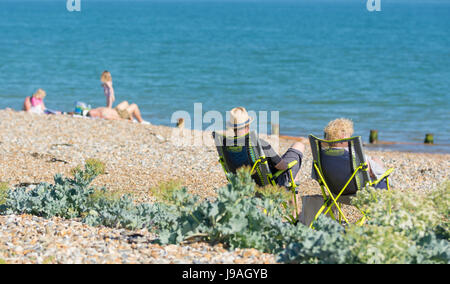 Menschen faulenzen an einem Strand an einem heißen Summers-Tag in Großbritannien. Stockfoto