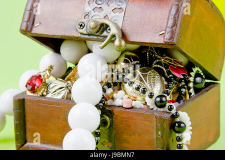 kleine Box mit Schätze auf einen hellgrünen Hintergrund Stockfoto