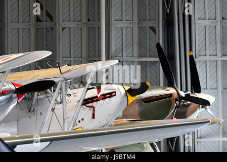 1930er Jahre alte Kämpfer in einem Hangar. Hawker Nimrod, Hawker Fury, Hawker Hurricane und Supermarine Spitfire Stockfoto