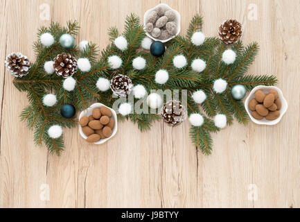 Schokolade überzogen Mandeln in kleinen weißen Schalen um Weihnachts-Dekoration mit textfreiraum angeordnet. Stockfoto