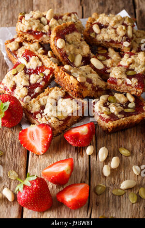 Müsliriegel mit Erdbeermarmelade, Samen und Nüssen Nahaufnahme auf dem Tisch. vertikale Stockfoto