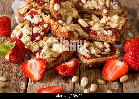 Müsliriegel mit Erdbeermarmelade, Samen und Nüssen Nahaufnahme auf dem Tisch. Horizontale Stockfoto