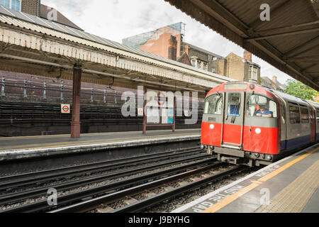 Ein Zug der Piccadilly-Linie, der die U-Bahn-Station Barons Court der Piccadilly- und District-Linie, London, Großbritannien, erreicht Stockfoto