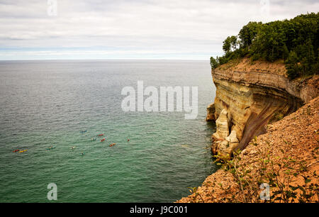 Blick von oben der kleinen Kajakfahrer entlang der Küstenlinie des dargestellten Felsen, der Oberen Halbinsel von Michigan, USA Stockfoto
