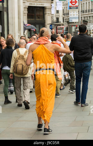 Hare-Krishna-Anhänger singen und tanzen in der Regent Street in central London, UK Stockfoto