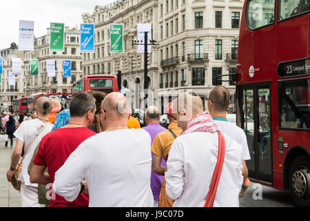 Hare-Krishna-Anhänger singen und tanzen in der Regent Street in central London, UK Stockfoto