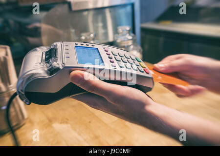 Nahaufnahme einer Hand mit einer Kreditkarte terminal bezahlen Stockfoto