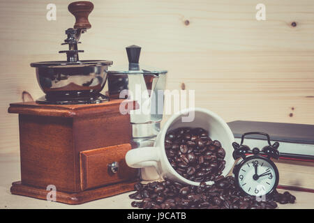 Schleifer, Kaffee Kaffeemaschine Wecker auf Kaffeebohnen. Kaffeetasse voll Kaffee Bohnen. Stockfoto