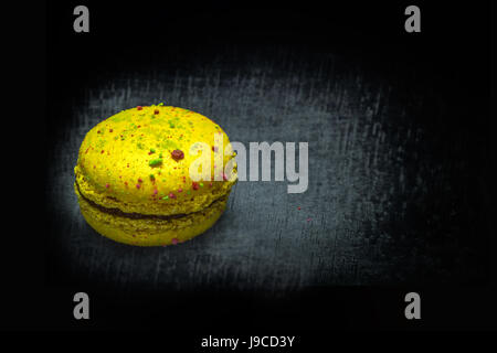 Süße Zitrone Makronen oder Macaron auf schwarzer Holztisch. Platz für Text. Stockfoto
