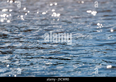 Wasser mit Bokeh Hintergrund. Wasseroberfläche mit Wellen glitzern in der Sonne Stockfoto