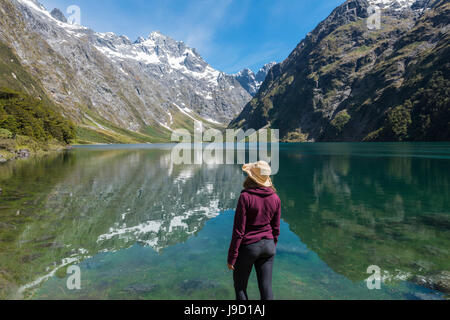 Weibliche Wanderer Sonne Hut steht am Ufer, See Marian, Fjordland National Park, Te Anau, Southland, Südinsel, Neuseeland Stockfoto