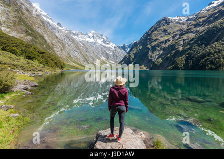 Weibliche Wanderer Sonne Hut steht am Ufer, See Marian, Fjordland National Park, Te Anau, Southland, Südinsel, Neuseeland Stockfoto