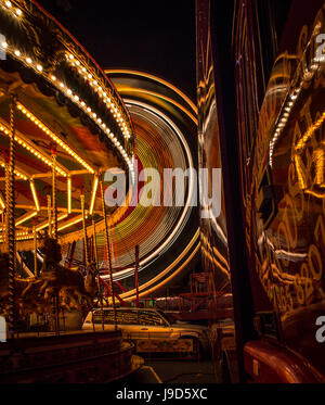 Leichte Spuren vom Karussell und Riesenrad im Hintergrund im St Giles fair, Oxford.  Beide Spuren sind Refelected in der bequem geparkten artic Stockfoto