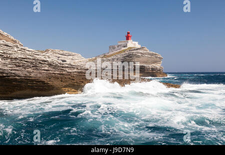 Wellen des türkisblauen Meeres stürzt auf dem weißen Granitfelsen und Leuchtturm, Lavezzi-Inseln, Bonifacio, Korsika, Frankreich Stockfoto