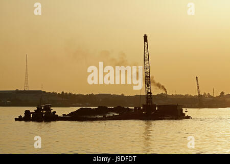 Schlepper und Kahn auf Co-Chien-Fluss (Zweig des Mekong) bei Sonnenuntergang, Vinh Long, Mekong-Delta, Vietnam Stockfoto