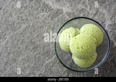 Grüner Tee Matcha Eisportionierer Kristallschale auf grauem Stein Hintergrund Stockfoto