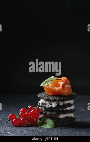 Schwarz-Cracker mit Lachs und Beeren Stockfoto