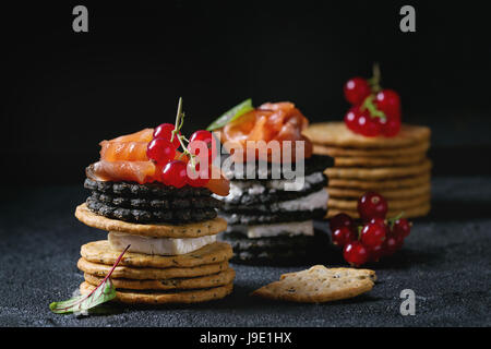 Schwarz-Cracker mit Lachs und Beeren Stockfoto