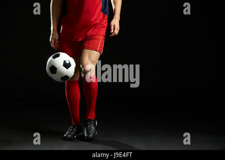 Der Profi-Fußballer mit Ball im Studio hautnah Stockfoto