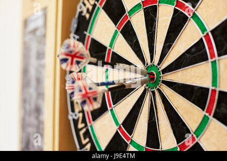 Nahaufnahme der Dartscheibe mit drei Darts im Bullseye Stockfoto