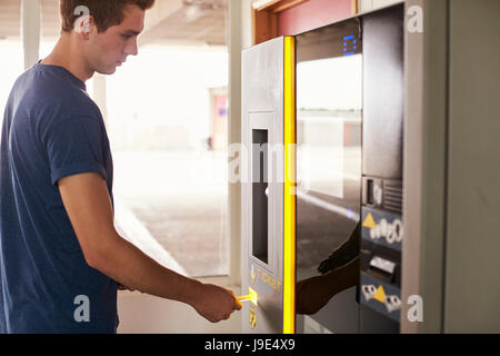 Junger Mann für Parkplätze am Automaten bezahlen Stockfoto