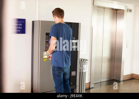 Junger Mann für Parkplätze am Automaten bezahlen Stockfoto