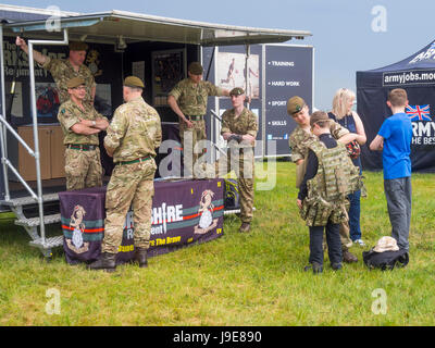 Eine Armee Rekrutierung anzeigen von The Yorkshire Regiment mit einem Soldaten versuchen Kit auf einen kleinen Jungen auf Skylive Airshow in Durham Tees Valley Airport 2017 Stockfoto