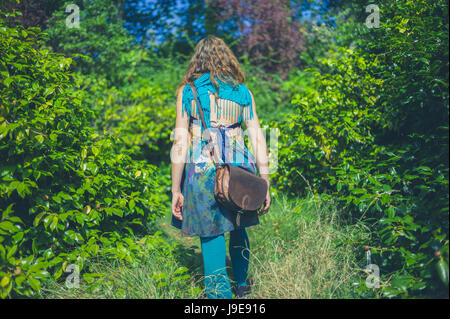 Eine junge Frau trägt eine ungewöhnliche Outfit geht im Wald spazieren Stockfoto