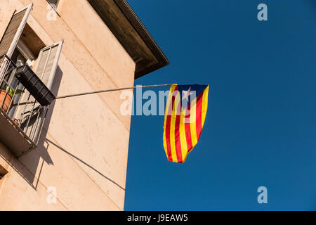 Flagge der Unabhängigkeitsbewegung von Katalonien, genannt Estelada (inoffiziell), in einer Straße in der Innenstadt von Girona, Costa Brava, Katalonien, Spanien. Stockfoto