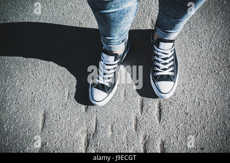 Schwarz / weiß neue Turnschuhe, Teenager Füße auf städtischen Bürgersteig stehen Stockfoto