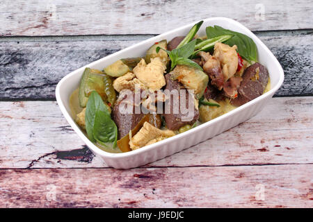 Thai beliebtes Rezept, grün Pouletcurry in Kokosnussmilch mit langen Auberginen und gekochtes Huhn Blut. Stockfoto