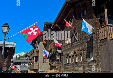 Schweizer Chalet mit Flaggen des Landes, des Kantons und der Gemeinde Blatten, Lötschental, Wallis, Schweiz Stockfoto