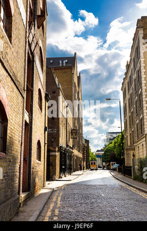 Gepflasterte Straße mit alten Lagerhäusern entlang Wapping High Street, London, UK Stockfoto