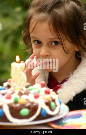 Kleines Mädchen Verkostung zuckerguss von Geburtstag Kuchen Stockfoto