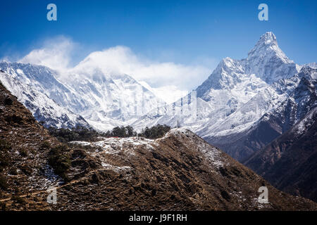 Ama Dablam steigt auf 6856 Meter im Sagarmatha Nationalpark, Nepal.  Mt. Everest und Lotse sind eingehüllt in Wolken auf der linken Seite. Stockfoto