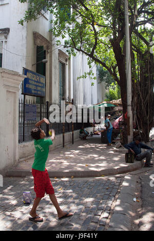 Jungs spielen Cricket in der Straße vor Metcalfe Hall, Kolkata Indien Stockfoto