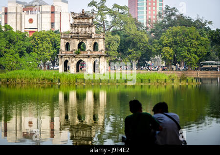 Paar neben Hoan Kiem Lake in Hanoi, Vietnam sitzen Stockfoto