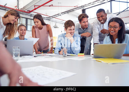 Junges Unternehmen Team versammelt rund zwei Laptops im Büro Stockfoto