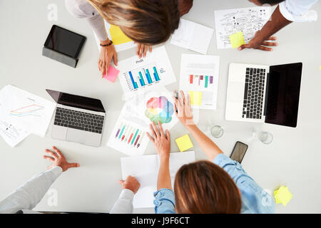 Schreibtisch und Kollegen an einem Geschäft Brainstorming, Draufsicht Stockfoto