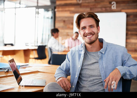 Young lässig gekleidet weißen Mann im Büro suchen, Kamera Stockfoto