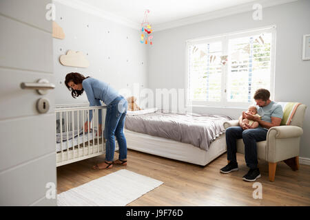 Mutter, aus denen Bett im Kinderzimmer Kinderbett für Neugeborenen Sohn Stockfoto
